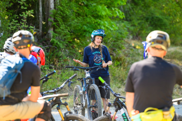 A mountain bike coaching riders on trail