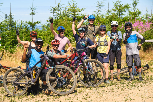 A mountain bike and instructor and their group pose for the camers